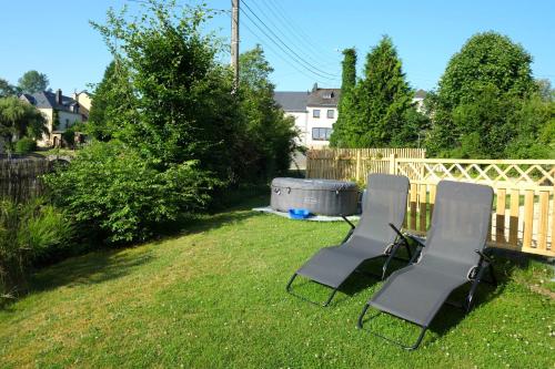 two chairs and a hot tub in a yard at Au Petit Bercail - Le Fonteny - Gîte 2 personnes in Chiny