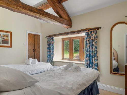 two beds in a room with a window at Pass the Keys Stunning 4 Bed Barn Conversion Hot Tub in Lake Side