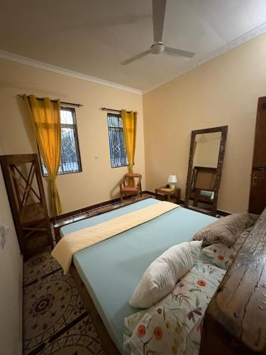 a bedroom with two beds and a mirror at ZanziBalkan House Nungwi in Nungwi