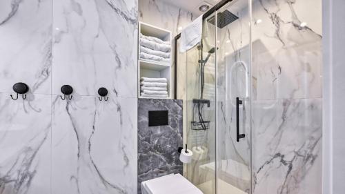 a bathroom with a shower and a toilet at Apartament w Lesie Sosnowym przy plaży - 5D Apartments in Międzywodzie