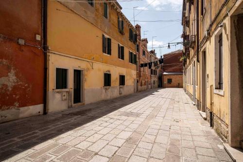 an empty street in an alley between two buildings at Bricola Biennale Apartments in Venice