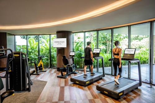 two people exercising on treadmills in a gym at Crowne Plaza Phu Quoc Starbay by IHG in Phu Quoc