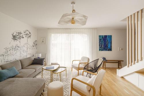 una sala de estar con un sofá y sillas en Ti Armor - Maison à 200m de la plage, en Bénodet