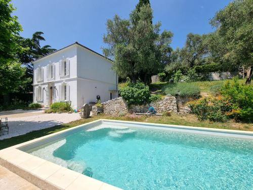 a large swimming pool in front of a house at Manor house with pool in Le Tignet