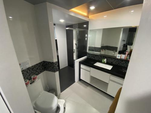 a bathroom with a toilet and a sink and a mirror at Lalaguna Villas Luxury Dive Resort and Spa in Puerto Galera