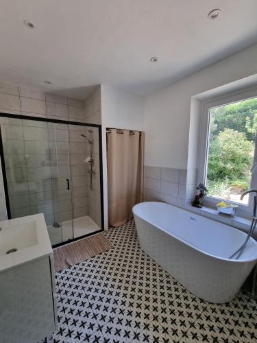 La salle de bains est pourvue d'une grande baignoire et d'une douche. dans l'établissement Manor house with pool, à Le Tignet