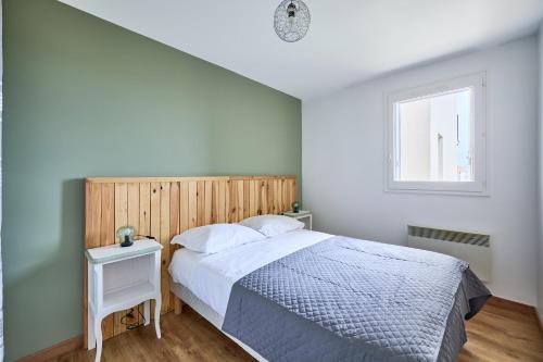 une chambre avec un lit et une fenêtre dans l'établissement Les Hirondelles - 800 m de la plage, à Courseulles-sur-Mer