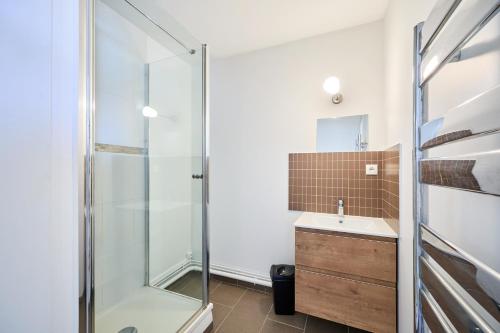 une salle de bain avec douche et lavabo dans l'établissement Les Hirondelles - 800 m de la plage, à Courseulles-sur-Mer