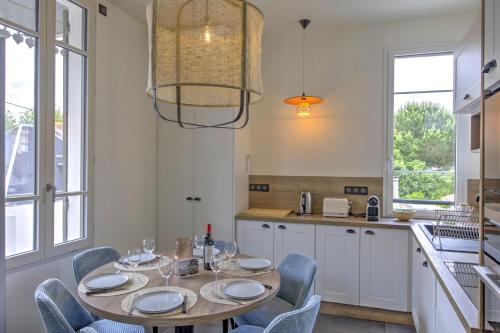 a dining room with a table and chairs in a kitchen at Le Banc de Sable - A 5 min de la plage in Arcachon