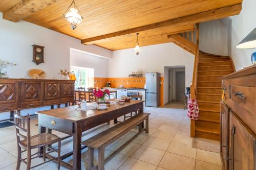 Il comprend une cuisine avec une table en bois et des plafonds en bois. dans l'établissement Belle Ferme Périgourdine, à Sainte-Foy-de-Longas