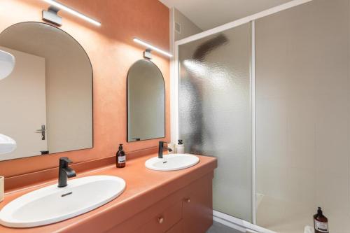 deux lavabos dans une salle de bain avec deux miroirs dans l'établissement Le Sedna - Quelques pas de la Plage de l’Écluse, à Dinard