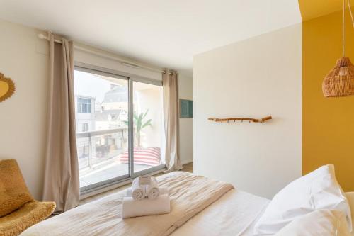 une chambre avec un lit et une grande fenêtre dans l'établissement Le Sedna - Quelques pas de la Plage de l’Écluse, à Dinard