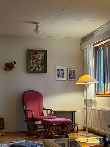 a living room with a chair and a lamp at Lakeside house in Sulkava in Sulkava
