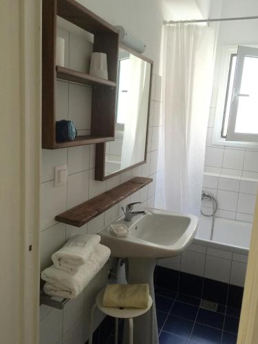 a bathroom with a sink and a mirror and a tub at Popy Apartments in Ierapetra