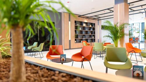 a lobby with colorful chairs and plants at Hotel Pelegrin Plava Laguna in Umag