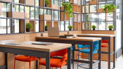 an office with two tables and chairs and windows at Hotel Pelegrin Plava Laguna in Umag
