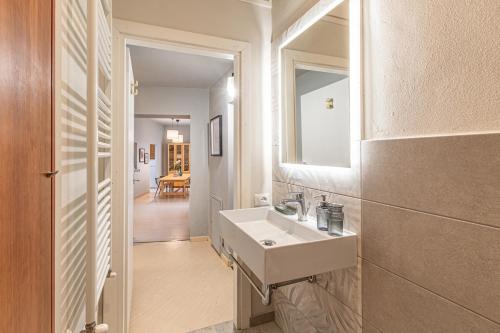 a white bathroom with a sink and a mirror at Nuovo con vista in pieno centro Storico in Siena