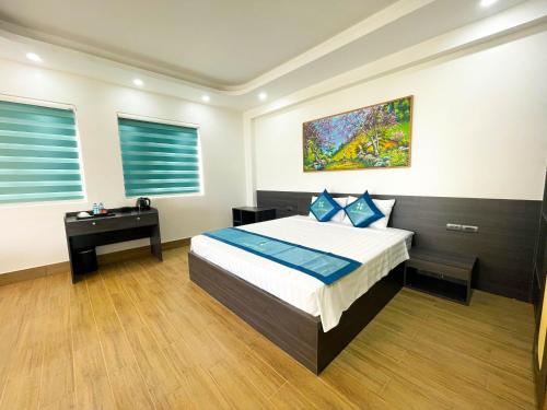 a bedroom with a bed and a desk in it at Xanh Melody Resort in Bắc Ninh