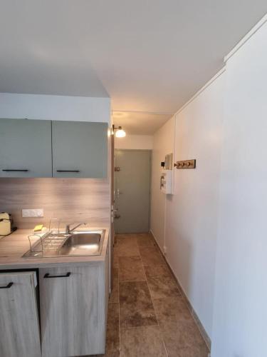 une cuisine avec un évier et un comptoir dans l'établissement Le Sunrise - Appartement à deux pas de la plage, à Narbonne
