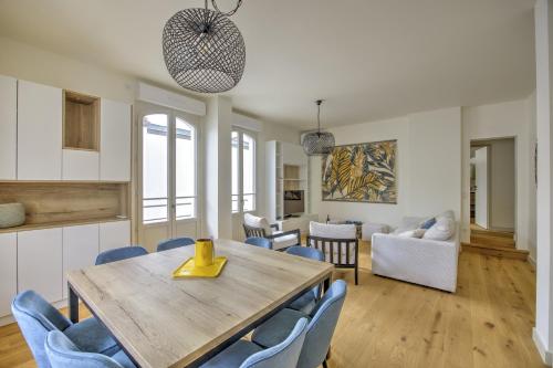 une salle à manger avec une table en bois et des chaises bleues dans l'établissement L'instant Bassin - Proche plage dArcachon, à Arcachon