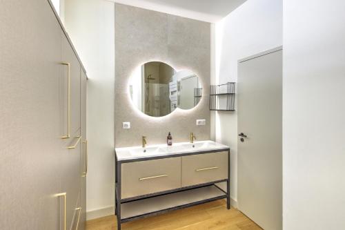 une salle de bain avec un lavabo et un miroir dans l'établissement L'instant Bassin - Proche plage dArcachon, à Arcachon