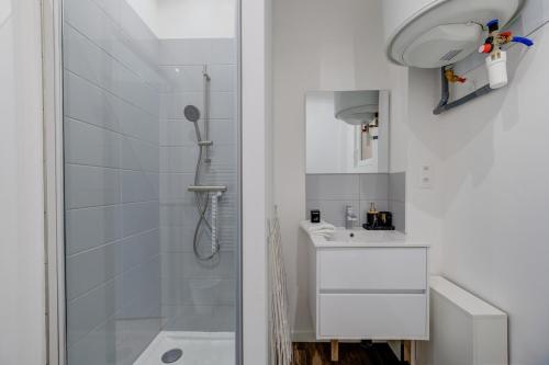 une salle de bain blanche avec une douche et un lavabo dans l'établissement Jacinthe - 2V - Bureau - Wifi, à Tours