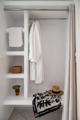 a room with white towels and a hat on a shelf at Dryoussa Apartments in Mesókampos