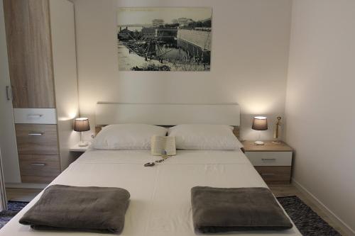 a bedroom with a large white bed with two pillows at Studio R&B in Zadar
