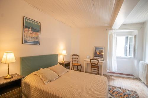 a bedroom with a bed and a window and chairs at Appartement 5 personnes in Olmeto
