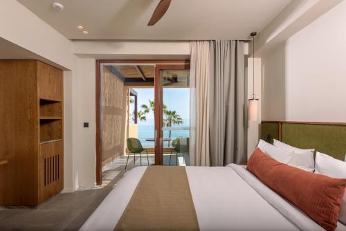 a bedroom with a bed and a view of the ocean at Blue Sea Beach Affiliated By Melia in Stalida