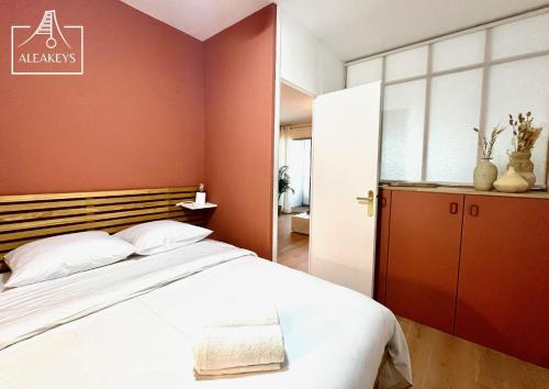 une chambre avec un grand lit et un mur rouge dans l'établissement L'Alizés T2 rénové avec clim, parking, Wi-Fi, accès plage directe, à La Grande Motte