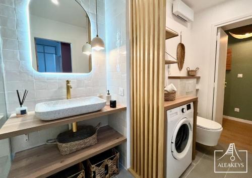 une salle de bain avec un lavabo et une machine à laver dans l'établissement L'Alizés T2 rénové avec clim, parking, Wi-Fi, accès plage directe, à La Grande Motte