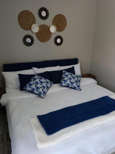 a bed with blue and white sheets and pillows at Tuis in Kimberley