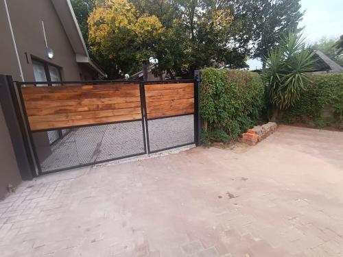 a wooden fence with a gate in front of a house at Tuis in Kimberley