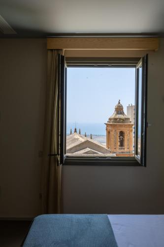 a bedroom window with a view of a building at Domus Terravecchia in Agrigento