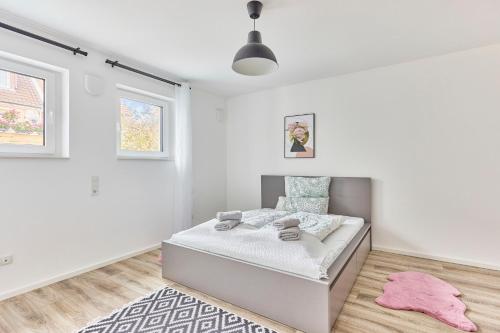 a white bedroom with a bed and a pink rug at Zentrale Lage Netflix Queensize Bett in Bruchsal