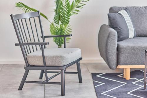 a chair in a living room next to a couch at Zentrale Lage Netflix Queensize Bett in Bruchsal