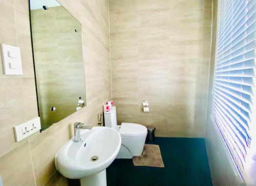 a bathroom with a sink and a toilet and a mirror at Lalaguna Villas Luxury Dive Resort and Spa in Puerto Galera