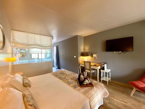 a bedroom with a bed and a tv on the wall at La Lune De Mougins - Hotel & Spa in Mougins