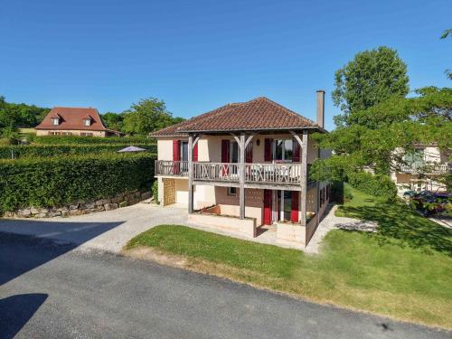 a house with a porch and a balcony at Domaine d'Essendiéras in Saint-Médard-dʼExcideuil