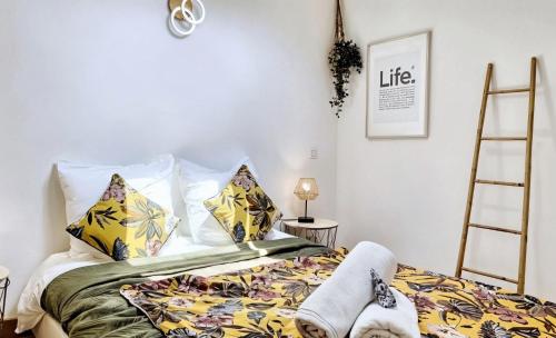 - une chambre avec un lit doté d'oreillers colorés et d'une échelle dans l'établissement FRGK 