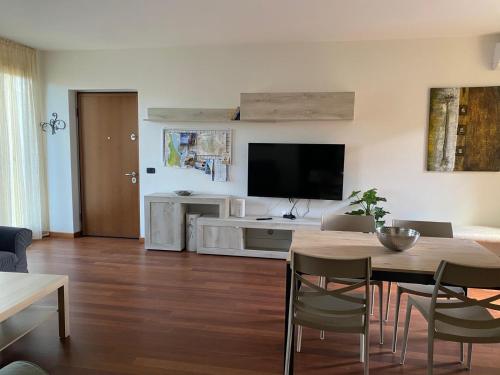 a living room with a table and a flat screen tv at Luca's Home in Villongo SantʼAlessandro