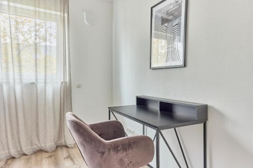 a desk and a chair in a room with a window at Elegantes 2 Zimmer Apartment Top Lage in Bruchsal