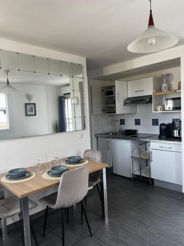 une cuisine avec une table et des chaises en bois ainsi qu'une salle à manger dans l'établissement Juan Les Pins 2BR Sunny Top Floor 50m Beach Central, à Antibes