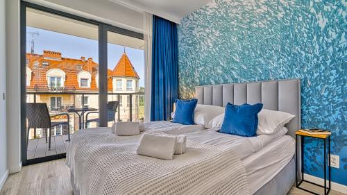 a bedroom with a bed and a large window at Rezydencja Niechorze 306 z Widokiem na Morze - 5D Apartments in Niechorze