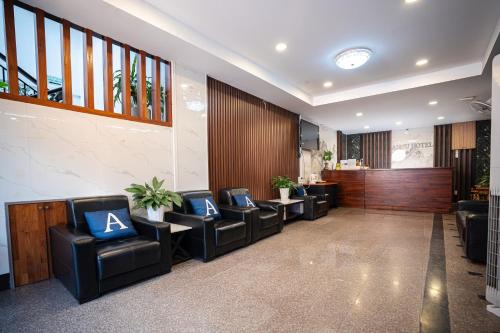 a waiting room with leather chairs and a bar at Anou Hotel in Vientiane