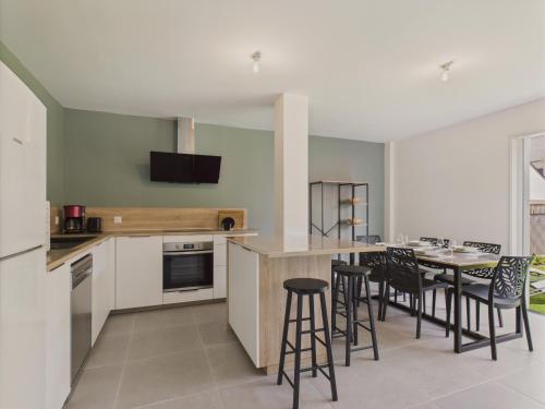 une cuisine avec une table et des tabourets dans une pièce dans l'établissement Jardin clos - Maison de plain-pied pour 4, à Le Tour-du-Parc