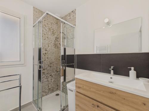 ein Badezimmer mit Waschbecken und Dusche in der Unterkunft Jardin clos - Maison de plain-pied pour 4 in Le Tour-du-Parc