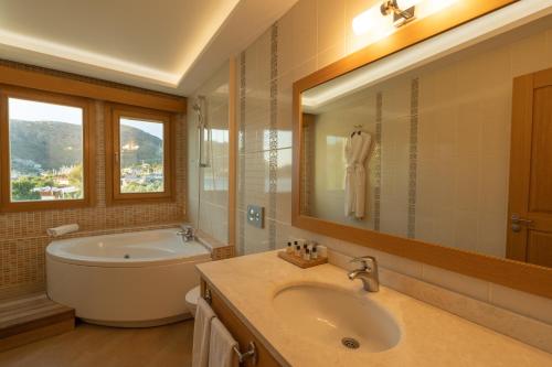 un bagno con vasca, lavandino e vasca da bagno di Loryma Luxury Hotel Bozburun a Bozburun