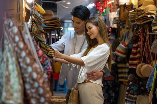 a man and a woman looking at items in a store at Chiang Mai Marriott Hotel in Chiang Mai